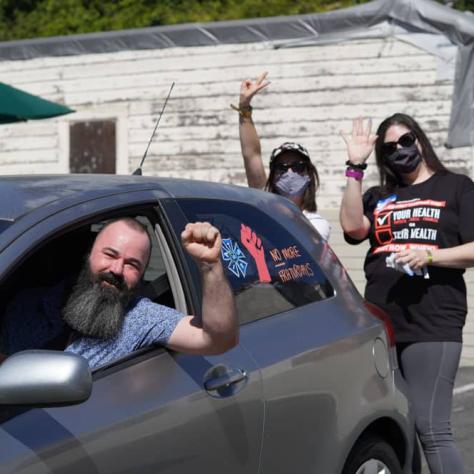 People posing with a decorated car. 