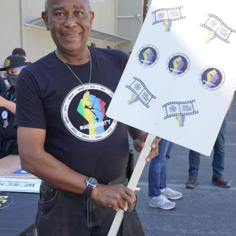 Man posing for a photo with sign.