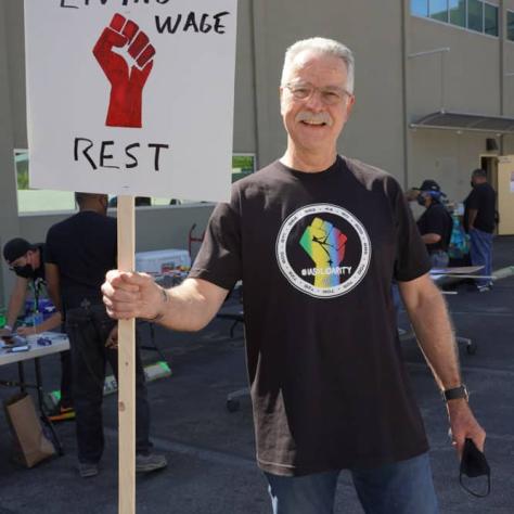 Man posing for a photo with sign.