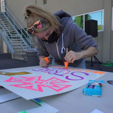 Woman drawing on a sign. 