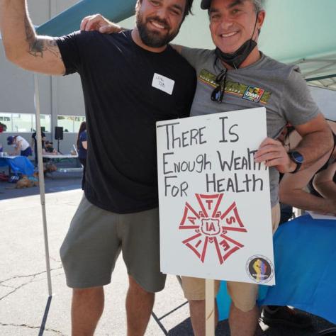 People posing together with signs. 