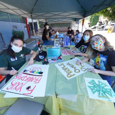 Table of people making signs. 