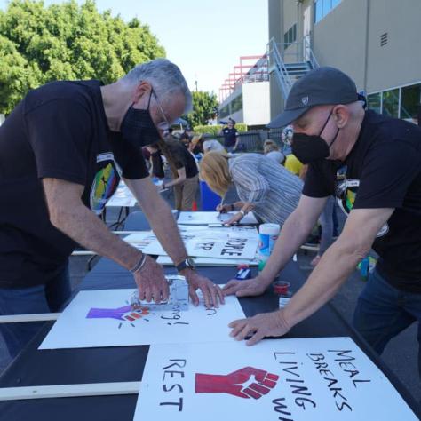 People making signs on a table. 