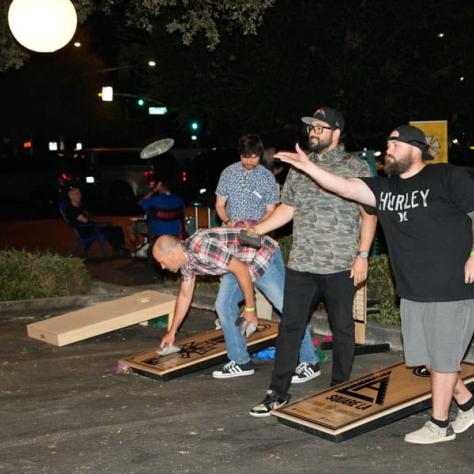 People playing cornhole.