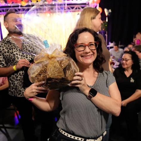 Woman posing for photo holding up prize. 