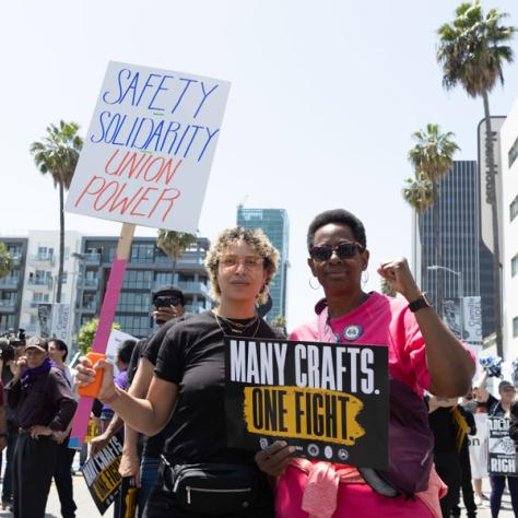 People marching with signs at rally.