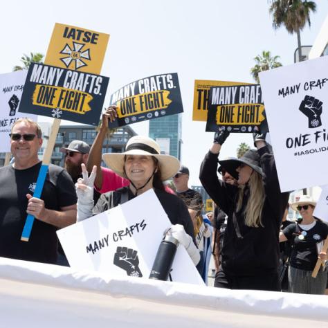 People marching with signs at rally.