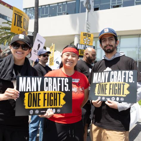 People marching with signs at rally.