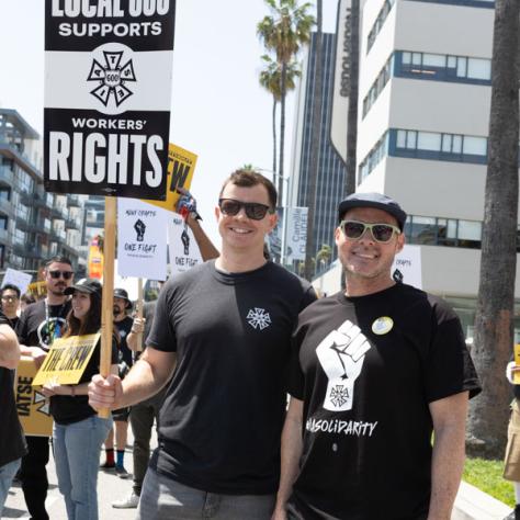 People marching with signs at rally.