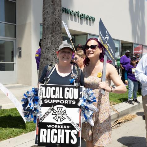 People marching with signs at rally.