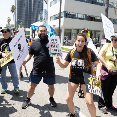 People marching with signs at rally.