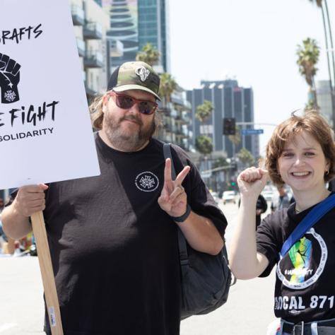 People marching with signs at rally.