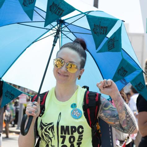 Woman with umbrella marching in rally. 