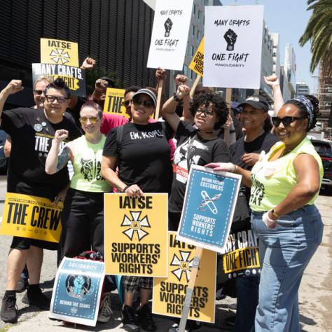 Group photo of people holding signs at rally. 