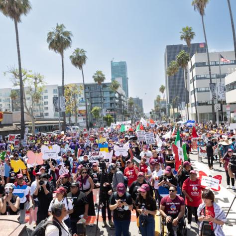 People marching with signs at rally.