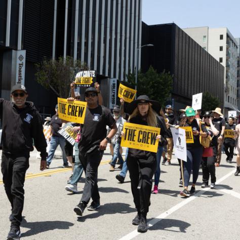 People marching with signs at rally.