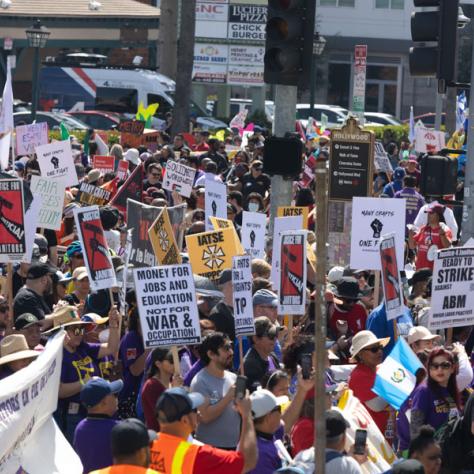 People marching with signs at rally.