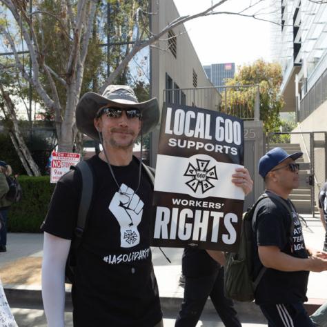 People marching with signs at rally.