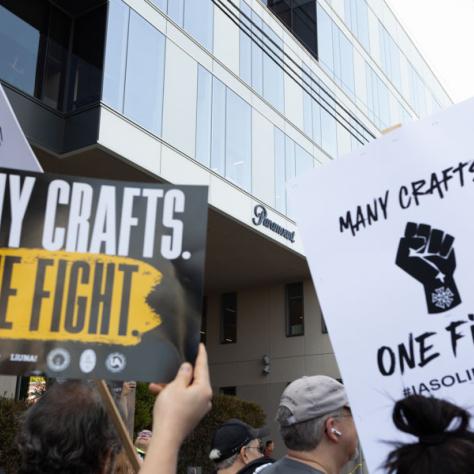 People marching with signs at rally.