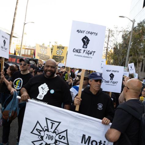 People marching with signs at rally.