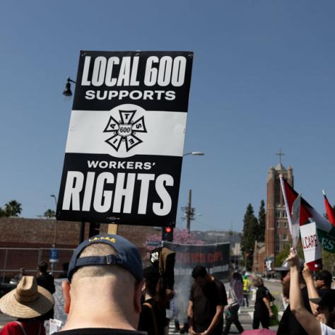 People marching with signs at rally.