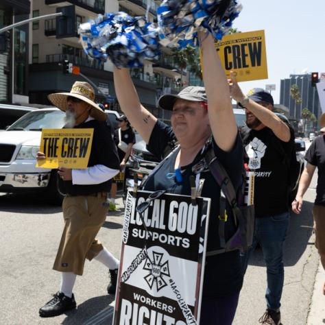 People marching with signs at rally.