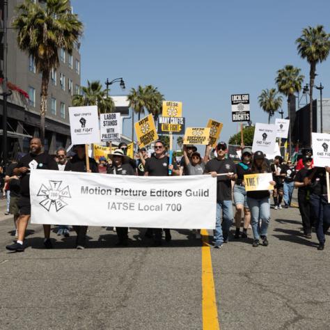 People marching with signs at rally.