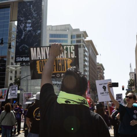 People marching with signs at rally.