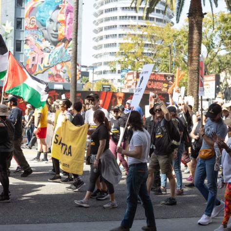 People marching with signs at rally.