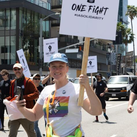 People marching with signs at rally.