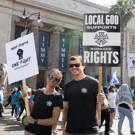 People marching with signs at rally.