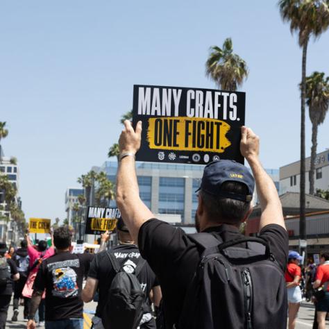 People marching with signs at rally.