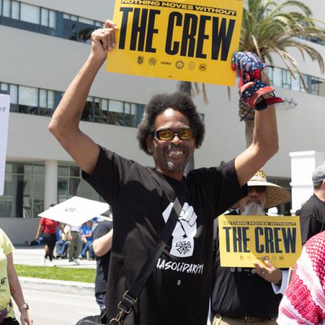 People marching with signs at rally.