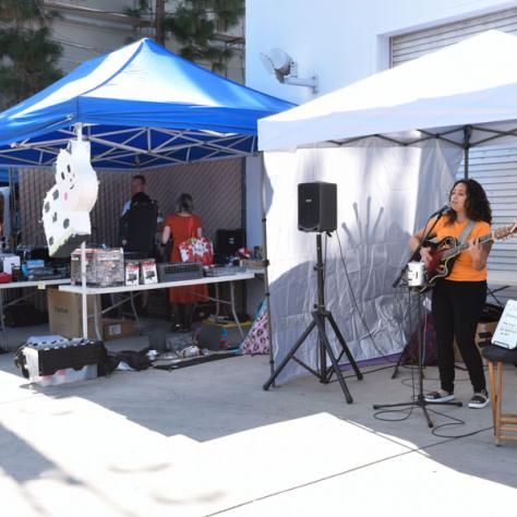 Woman playing music at yard sale. 