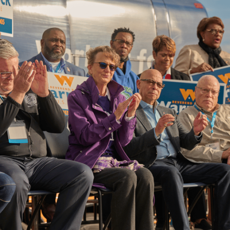 People sitting in chairs clapping. 