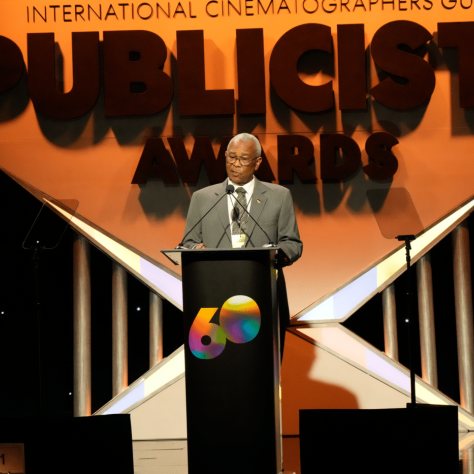 Man speaking at podium on stage. 