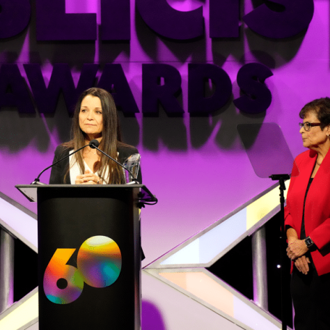 Woman at podium on stage. 