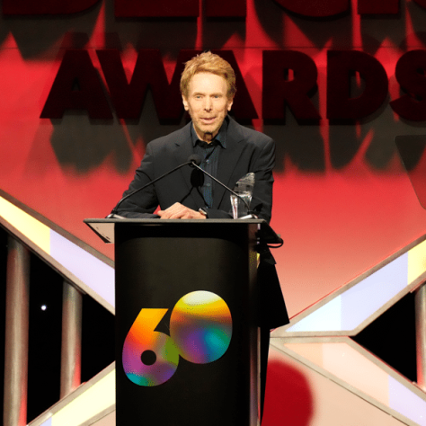 Man speaking at podium on stage. 