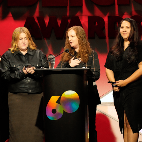 People standing on stage in front of podium.