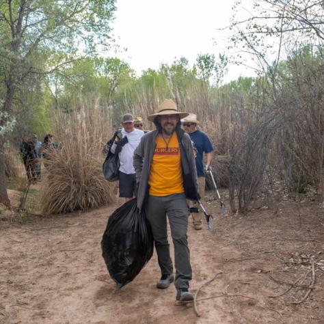 Man holding full trash bag. 