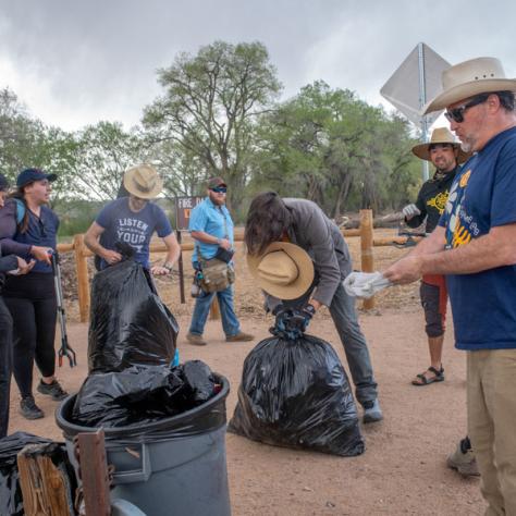 People standing with trash bags. 