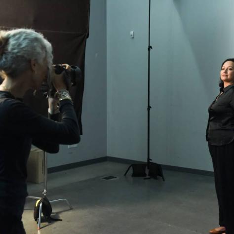 Woman taking still photo of another woman. 