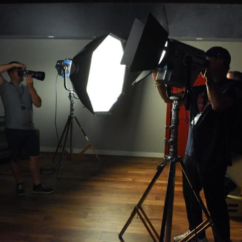 Photo of man behind large light. 