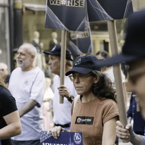 People marching in a parade with signs. 