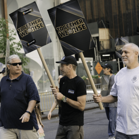 People marching in a parade with signs. 