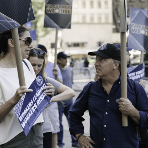 People holding signs and talking together. 