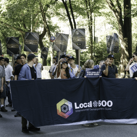 People marching in a parade with signs. 