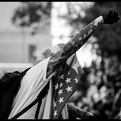 Man with American flag and fist in the air. 