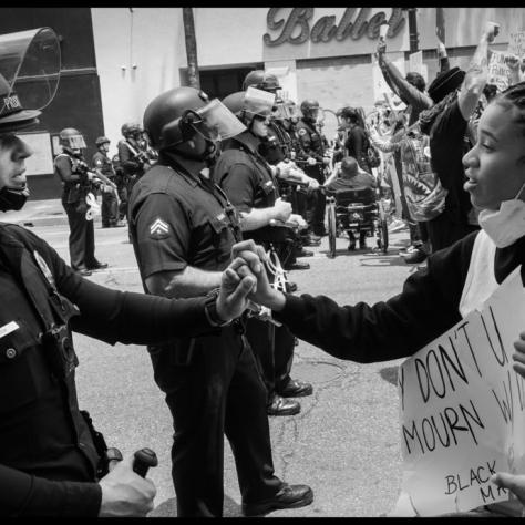 Woman and police officer in riot gear. 