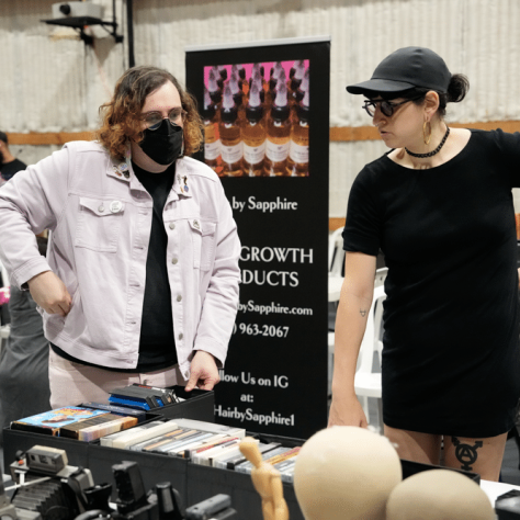 People talking to each other at an indoor yard sale. 